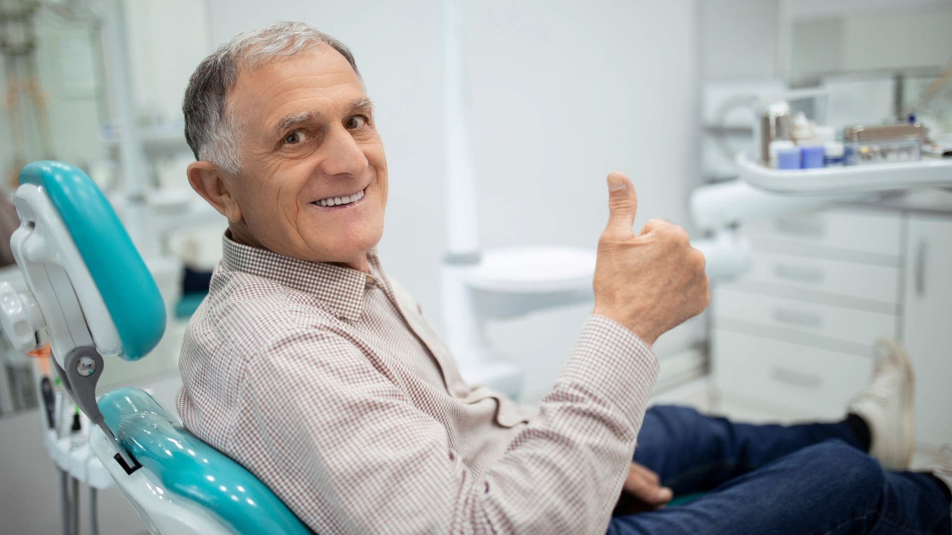 Smiling senior man giving a thumbs up after receiving dental care in Christchurch